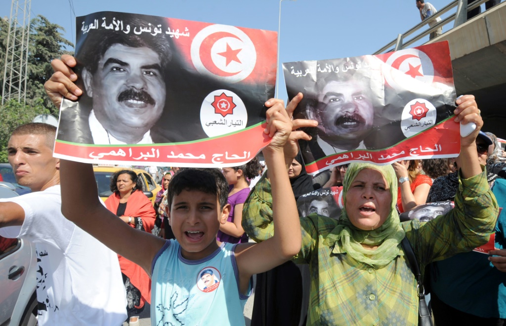 متظاهرون يرفعون صور النائب السابق المعارض محمد البراهمي خلال جنازته في تونس في 27 تموز/يوليو 2013 (أ ف ب)   