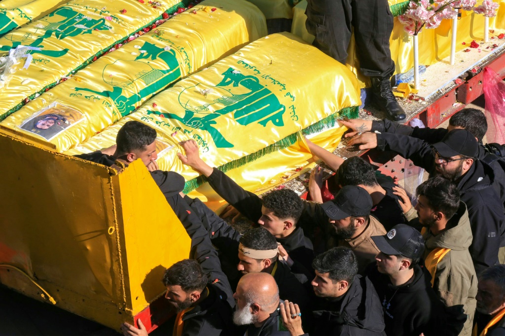 مشيعون يقفون قرب نعوش مقاتلين في حزب الله في قرية عيترون الحدودية في جنوب لبنان في 28 شباط/فبراير 2025 (أ ف ب)   