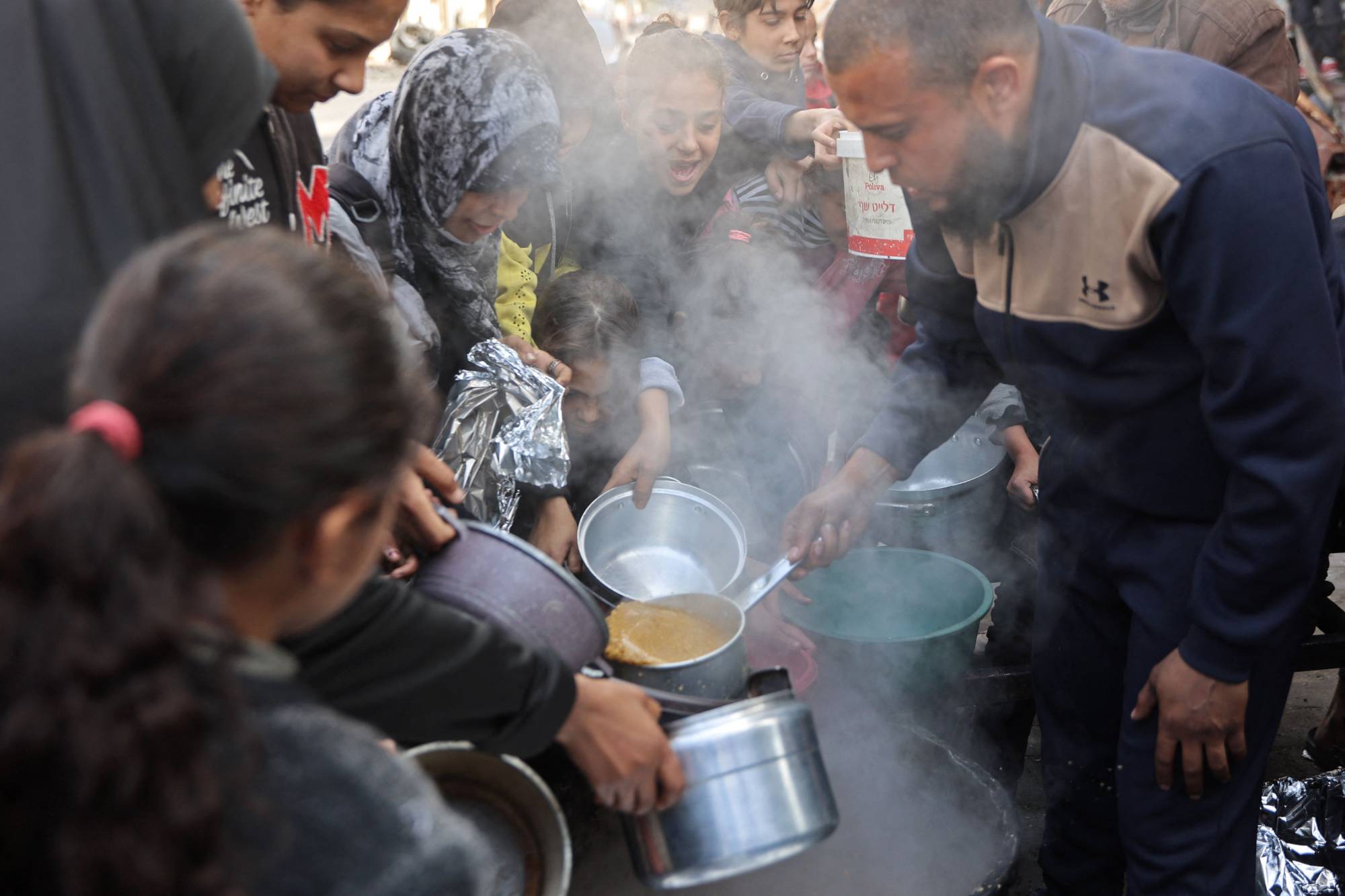 أطفال فلسطينيون يتجمعون للحصول على الطعام في غزة (أ ف ب)
