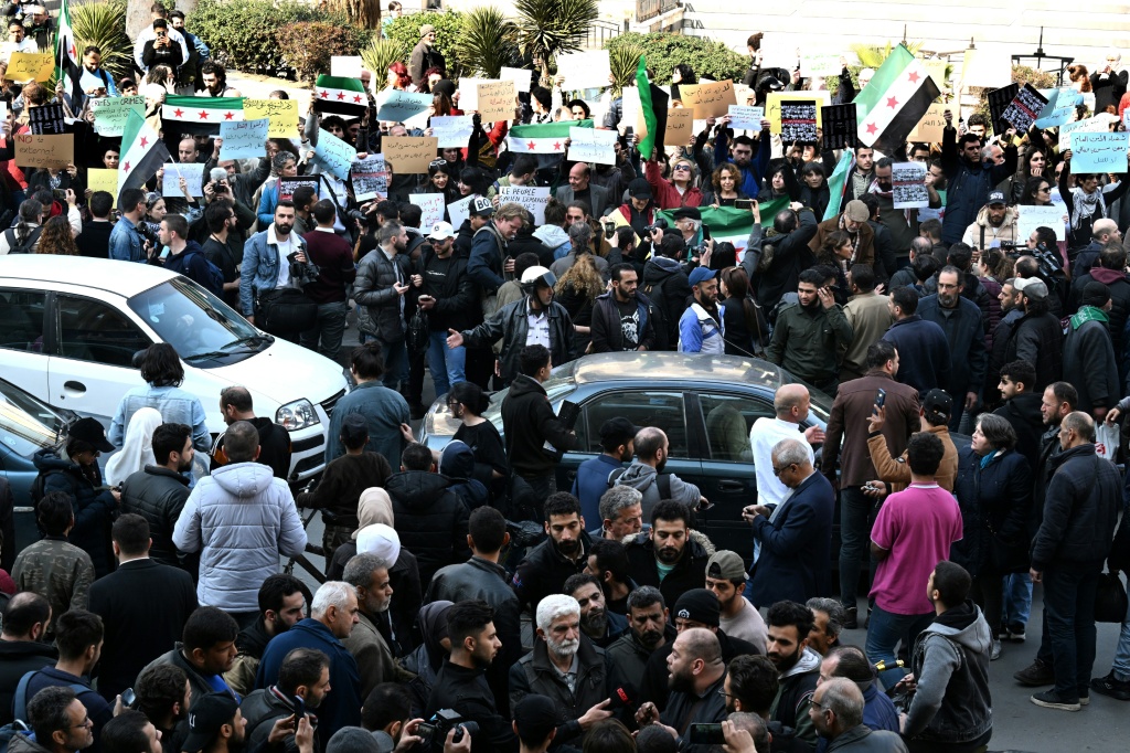 مشاركون في اعتصام دعا اليه ناشطون في ساحة المرجة بدمشق تنديدا بمقتل مدنيين في غرب سوريا في التاسع من اذار/مارس 2025 (أ ف ب)   