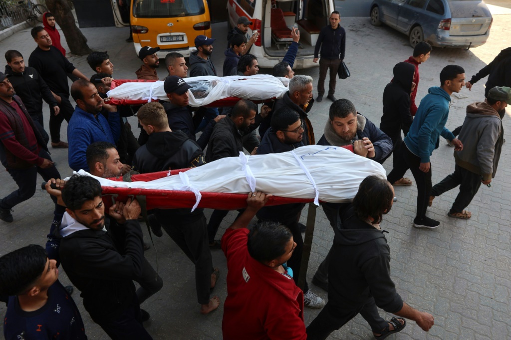   فلسطينيون يحملون جثتي شخصين بين الذين قتلوا الثلاثاء 11 آذار/مارس 2025 في غارة إسرائيلية في جنوب قطاع غزة (أ ف ب)   