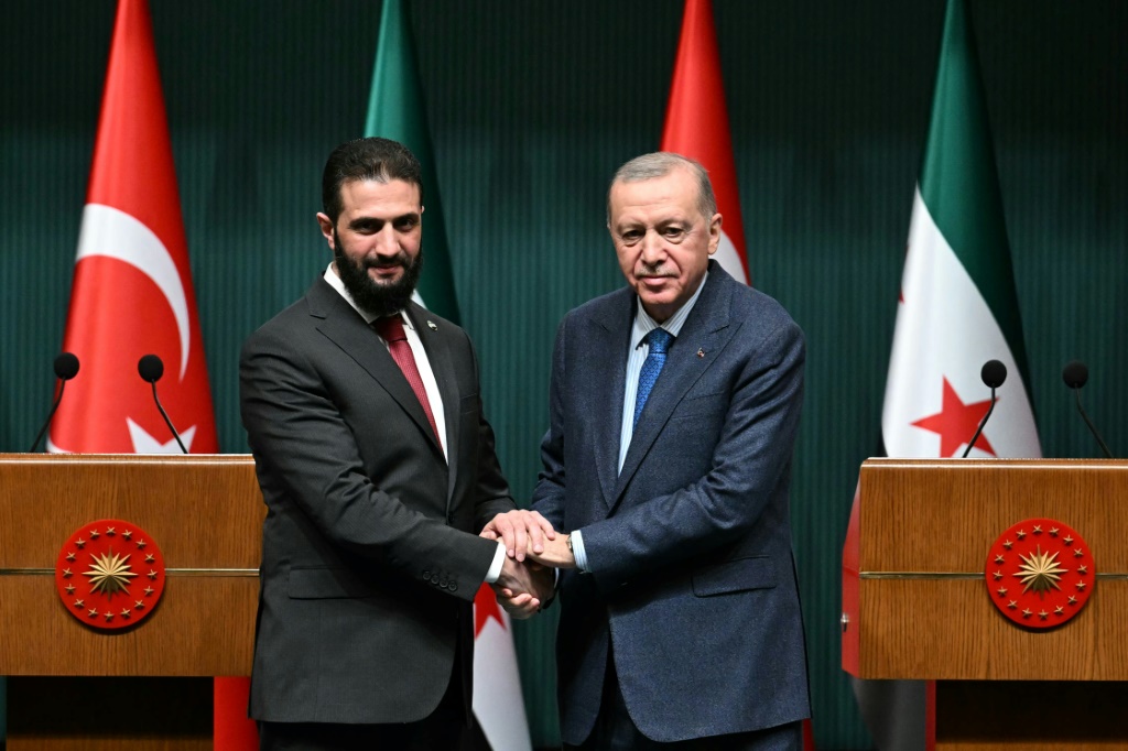 الرئيس التركي رجب طيب اردوغان والرئيس السوري الانتقالي أحمد الشرع يتصافحان خلال مؤتمر صحافي مشترك عقب اجتماعهما في القصر الرئاسي في أنقرة في 4 شباط/فبراير 2025 (أ ف ب)   