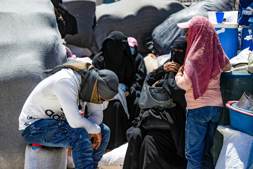    أشخاص يجلسون بجانب أمتعتهم في مخيم الهول في محافظة الحسكة شمال شرق سوريا في 28 تموز/يوليو 2024 (أ ف ب)   