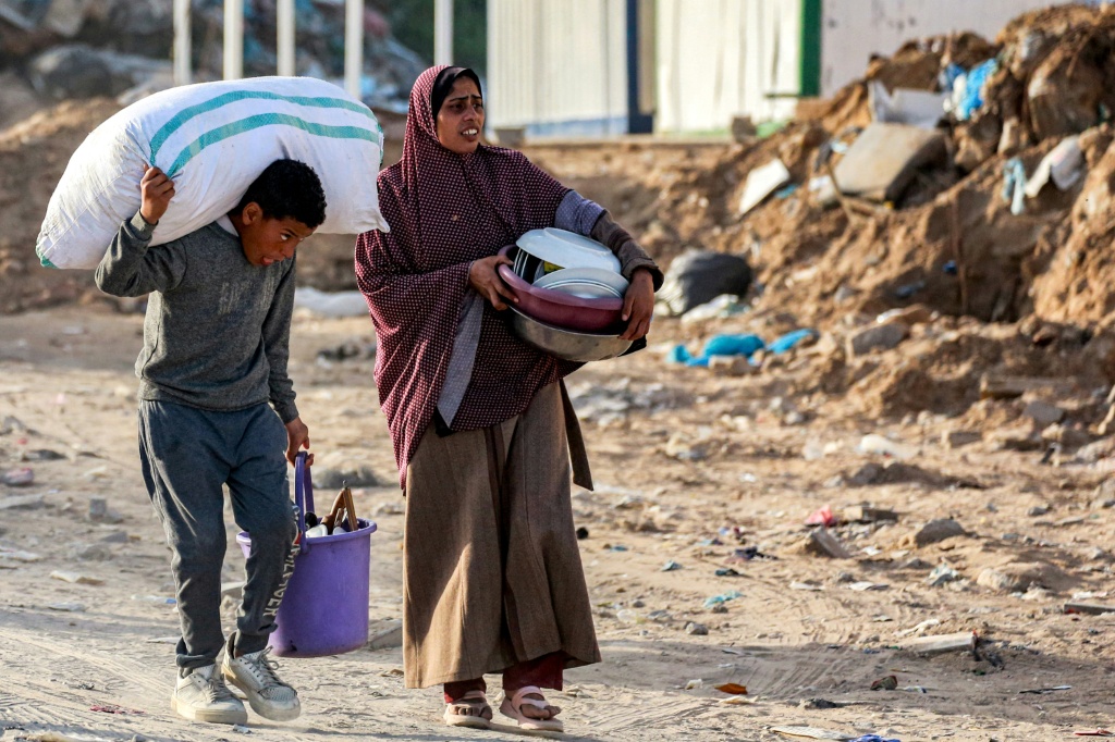 نازحون من بيت حانون في شمال قطاع غزة يصلون إلى مدينة غزة بينما يحملون أمتعتهم في 18 آذار/مارس 2025 (أ ف ب)   