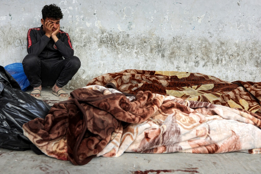 صورة مؤرخة في 18 آذار/مارس 2025 لفلسطيني قرب جثث أقارب له قتلوا ف الغارات الإسرائيلية على قطاع غزة (أ ف ب)   