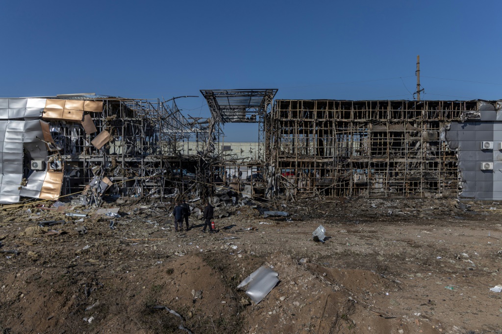 مارة ينظرون إلى مركز تسوق دمر في قصف مسيرات في أوديسا، في 21 آذار/مارس 2025 (أ ف ب)   