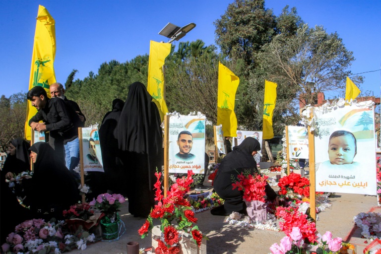 امرأة قرب أضرحة مقاتلين في حزب الله في عيترون في جنوب لبنان في اليوم الأول لعيد الفطر في 31 آذار/مارس 2025 (أ ف ب)