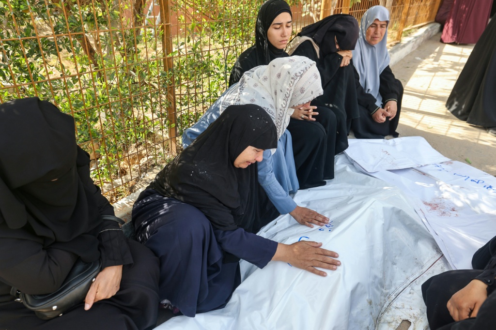 فلسطينيات ينتحبن على جثامين أحبائهن الذين قتلوا في الغارات الإسرائيلية، قبل موكب الجنازة في مستشفى ناصر في خان يونس جنوب قطاع غزة، في 2 نيسان/أبريل 2025 (أ ف ب)   