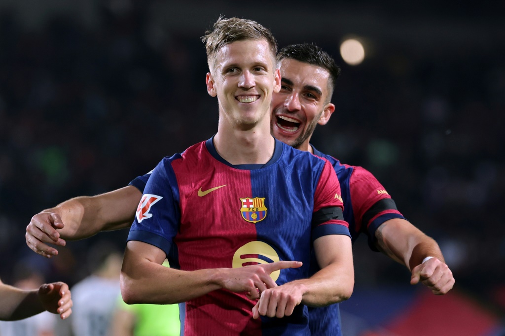 داني أولمو لاعب برشلونة يحتفل ومن خلفه فيران توريس بعد تسجيله ركلة جزاء في مرمى أوساسونا ضمن الدوري الإسباني لكرة القدم. برشلونة، في 27 آذار/مارس 2025 (أ ف ب)   