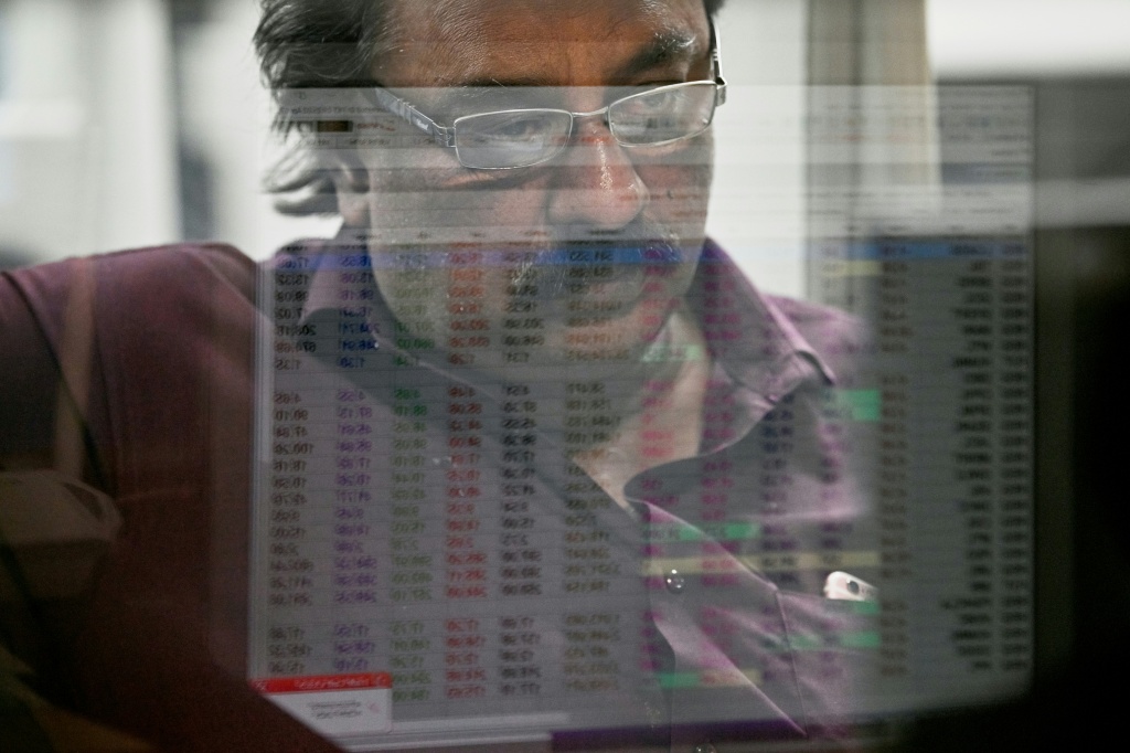وسيط أوراق مالية يتابع أسعار الأسهم على جهاز كمبيوتر أثناء جلسة التداول في بورصة باكستان للأوراق المالية حيث انخفض المؤشر وسط انهيار السوق العالمية، في كراتشي في 7 نيسان/أبريل 2025 (أ ف ب)   