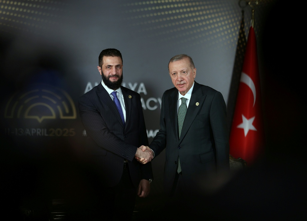 صورة نشرتها هيئة الصحافة التابعة للرئاسة التركية في 11 نيسان/أبريل 2025 وتظهر الرئيس التركي رجب طيب اردوغان وهو يصافح الرئيس السوري الانتقالي أحمد الشرع خلال منتدى أنطاليا للدبلوماسية (ا ف ب)   