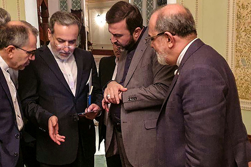 وزير الخارجية الايراني عباس عراقجي متحدثا الى اعضاء في وفد بلاده بعد مباحثات مع وفد اميركي في مسقط في 12 نيسان/ابريل 2025 (أ ف ب)   