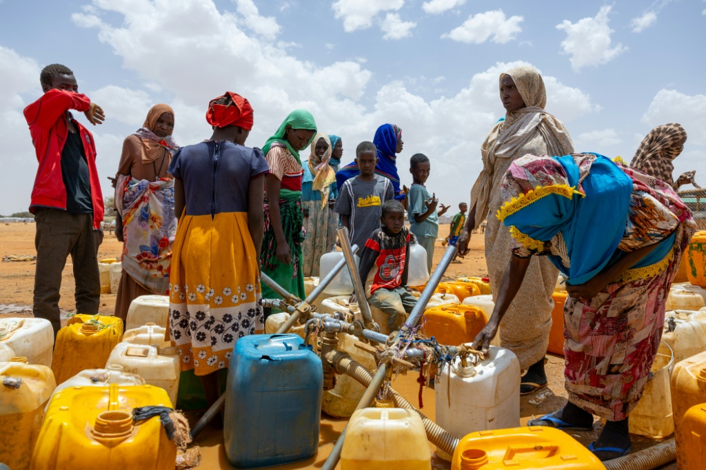 لاجئون سودانيون يملأون عبوات المياه في مخيم طولوم للاجئين في مقاطعة وادي فيرا في تشاد، في 8 نيسان/أبريل 2025 (أ ف ب)   