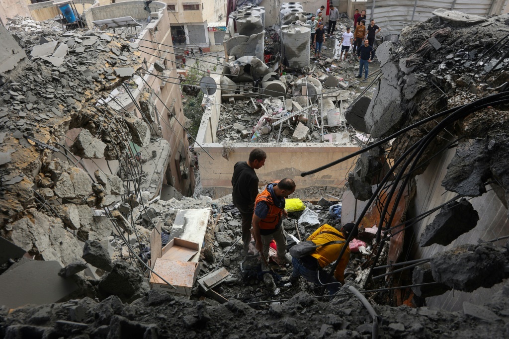 مسعفون فلسطينيون وسط الأنقاض بعد ضربة إسرائيلية على حيّ اليرموك في مدينة غزة، في 24 نيسان/أبريل 2024 (ا ف ب)   