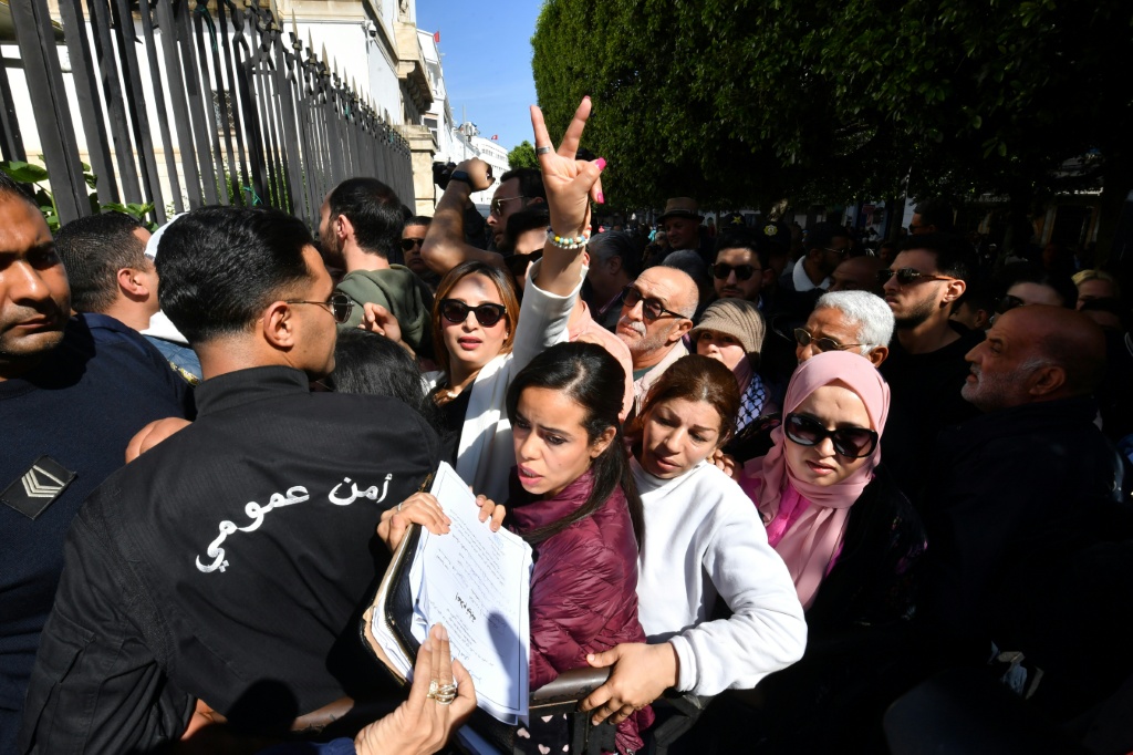 الصحافية التونسية والمدافعة عن حقوق الإنسان والعضو في جبهة الخلاص الوطني، ائتلاف المعارضة الرئيسي، شيماء عيسى ترفع علامة النصر أمام المحكمة في العاصمة تونس مع عقد ثالث جلسات محاكمة العشرات من شخصيات المعارضة التونسية في 11 نيسان/أبريل 2025 (أ ف ب)   