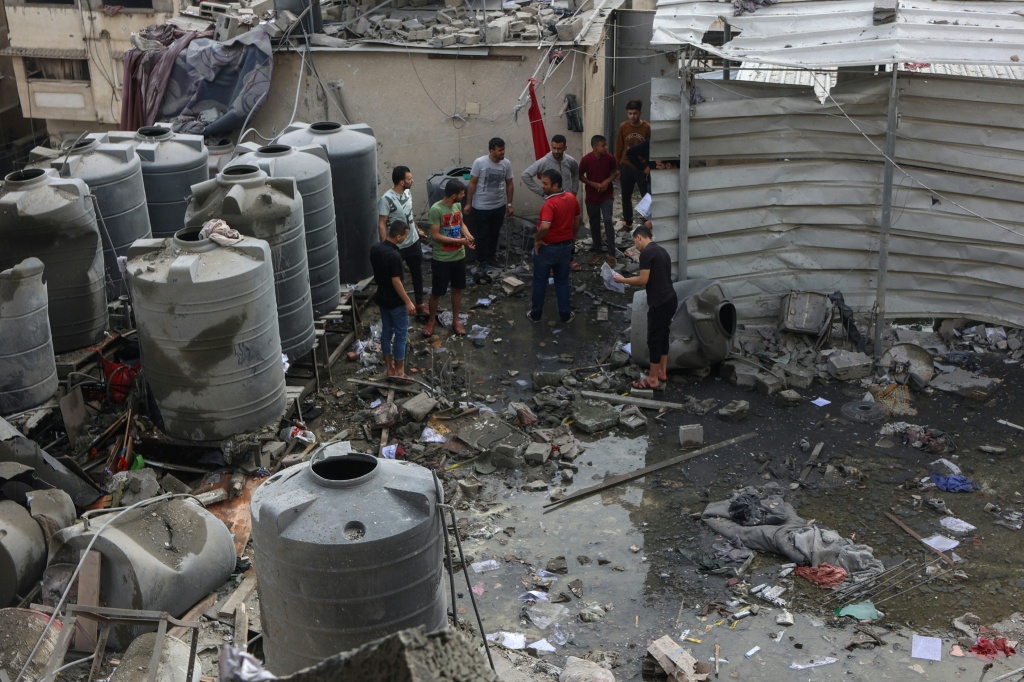 فلسطينيون يتفقدون الأضرار اثر ضربات إسرائيلية استهدفت شققا في مبنى سكني في شارع اليرموك في مدينة غزة في 24 نيسان/أبريل 2025 (أ ف ب)   