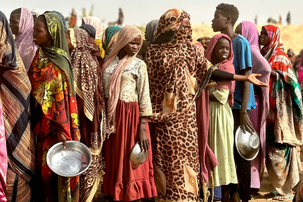 أشخاص فروا من مخيم زمزم للنازحين داخليا بعد سقوطه تحت سيطرة قوات الدعم السريع، يصطفون في 13 أبريل/نيسان 2025 للحصول على حصص غذائية (ا ف ب)   