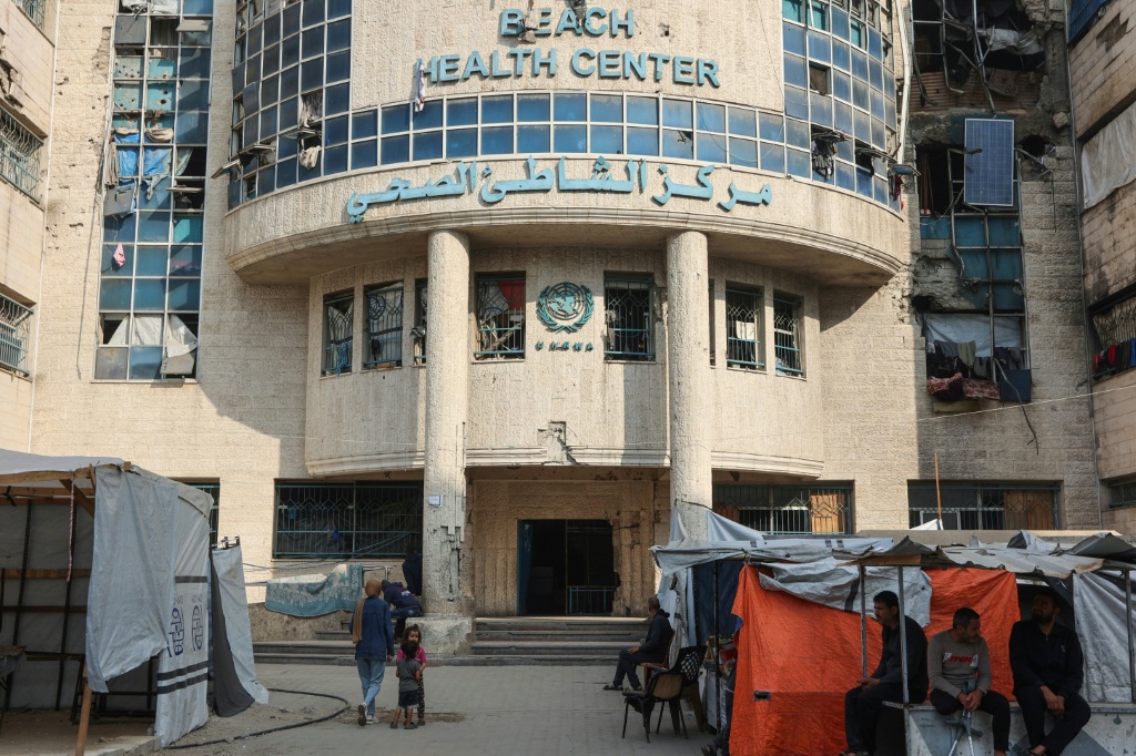 نازحون فلسطينيون بجوار خيامهم أعدوها بما تيسر لهم خارج العيادة التي تديرها الأونروا في مخيم الشاطئ للاجئين غرب مدينة غزة في 28 نيسان/أبريل 2025 (أ ف ب)   