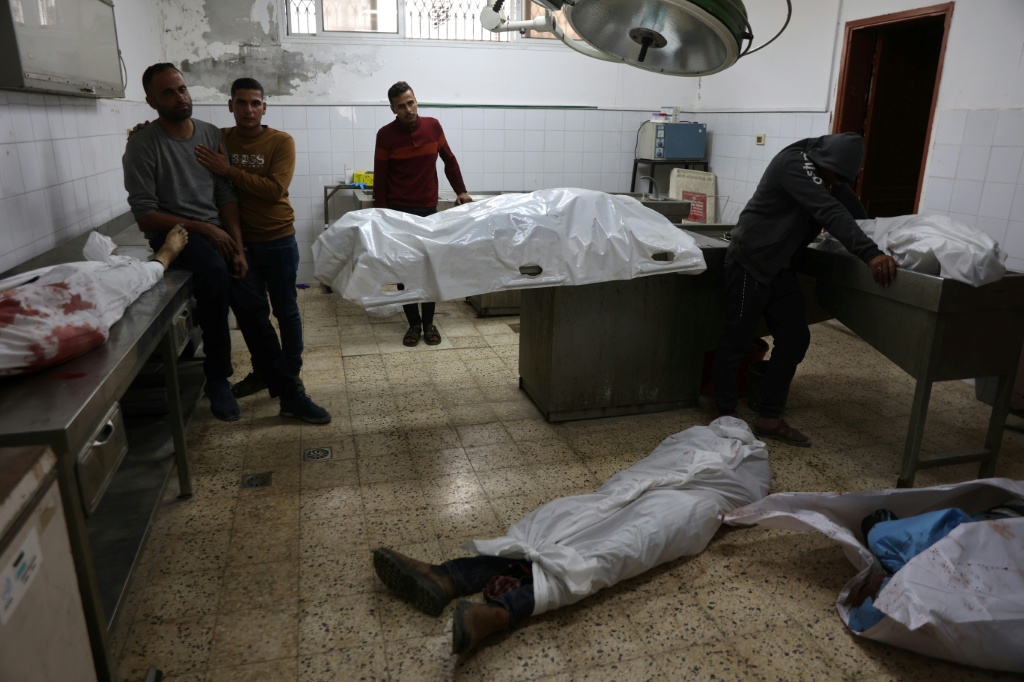 فلسطينيون في جوار جثث لاحبائهم قتلوا في غارة اسرائيلية في مستشفى الشفاء في مدينة غزة في 28 نيسان/ابريل 2025 (أ ف ب)   