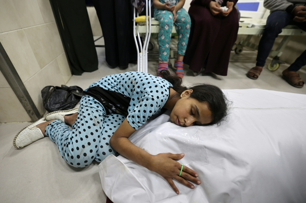 فتاة فلسطينية تبكي فوق جثمان أمها التي قتلت في غارة إسرائيلية في مستشفى العودة بمخيم النصيرات في وسط غزة في 7 أيار/مايو 2025 (أ ف ب)