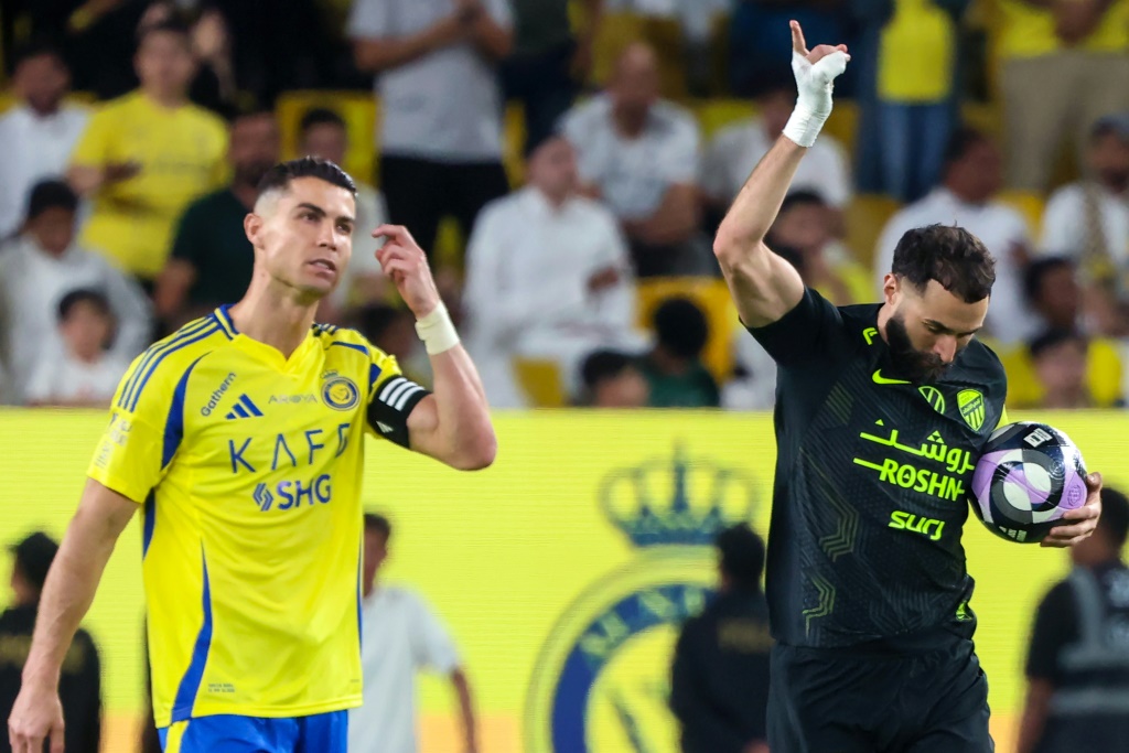    قاد بنزيمة (يمين) الاتحاد إلى الفوز على النصر ونجمه كريستيانو رونالدو (أ ف ب)
