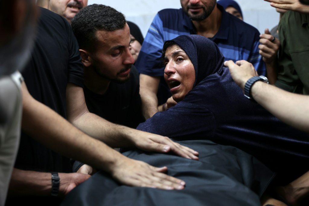 فلسطينية تبكي على جثة رجل في مستشفى الشفاء اثر ضربة إسرائيلية على المطعم التايلاندي ومحيطه في مدينة غزة في السابع من أيار/مايو 2025 (ا ف ب)