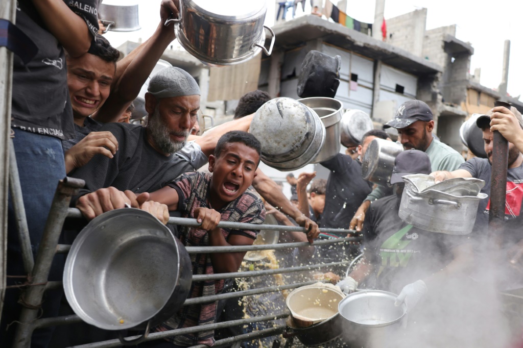فلسطينيون يسعون للحصول على حصصهم الغذائية خارج مركز توزيع مزدحم في بيت لاهيا في شمال قطاع غزة في 15 أيار/مايو 2025 (أ ف ب)