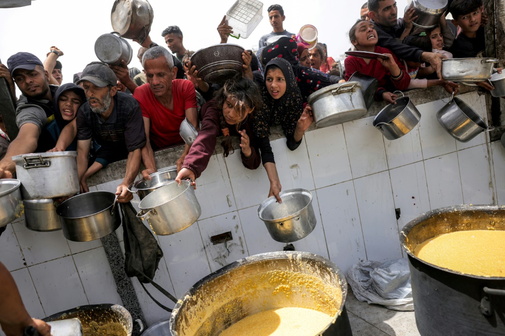 أشخاص ينتظرون أمام تكية طعام خيرية في بيت لاهيا في شمال قطاع غزة في 24 نيسان/أبريل 2025 (أ ف ب)   