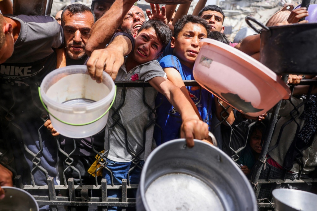    فلسطينيون يتزاحمون للحصول على وجبة طعام من منظمة إنسانية في جباليا في شمال قطاع غزة في 17 أيار/مايو 2025 (أ ف ب)