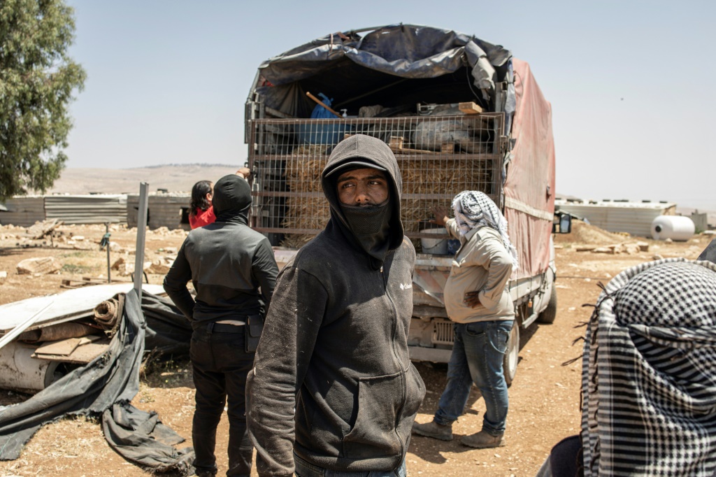    فلسطينيون يحملون امتعتهم على متن شاحنة في تجمع مغاير الدير (أ ف ب)   