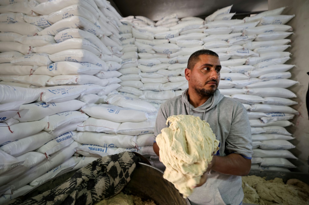 فلسطيني يعمل في مخبز في دير البلح وسط قطاع غزة بعد سماح إسرائيل بدخول عدد محدود من شاحنات المساعدات الإنسانية في 22 ايار/مايو 2025 (أ ف ب)