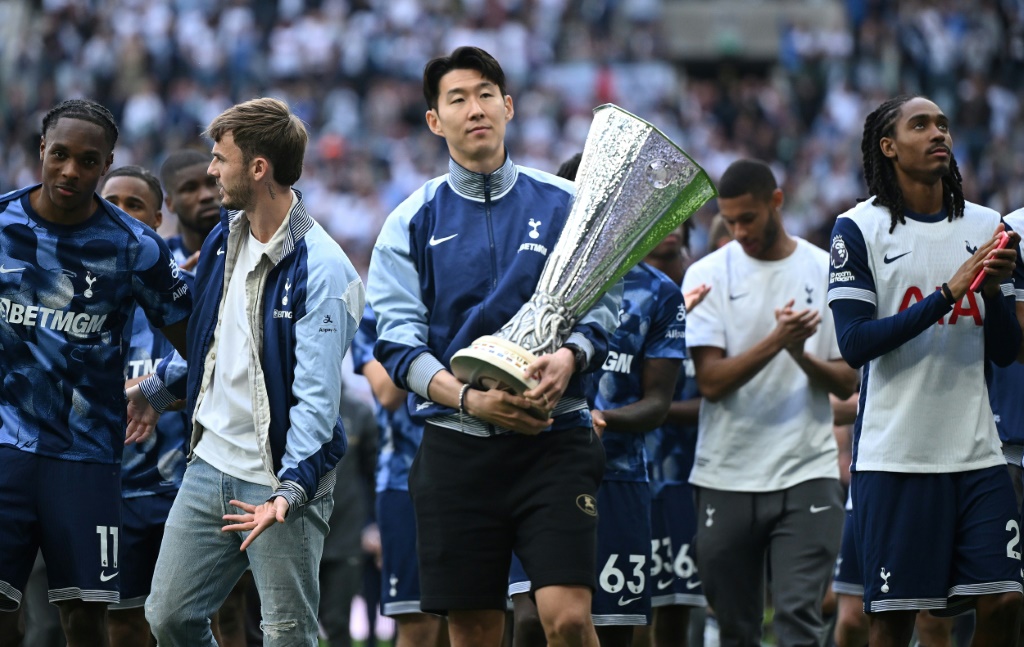   قائد توتنهام الانكليزي الدولي الكوري الجنوبي هيونغ-مين سون يحمل كأس الدوري الأوروبي بعد الفوز على مانشستر يونايتد (1-0) في المباراة النهائية في بلباو في 21 أيار/مايو 2025 (أ ف ب)