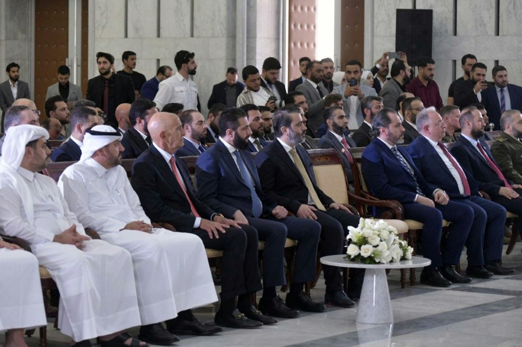   الرئيس السوري الانتقالي احمد الشرع ووزير الخارجية اسعد الشيباني والموفد الاميركي توماس باراك خلال حفل توقيع اتفاق في مجال الطاقة بين دمشق وائتلاف شركات دولية في 29 ايار/مايو 2025 في دمشق (أ ف ب)