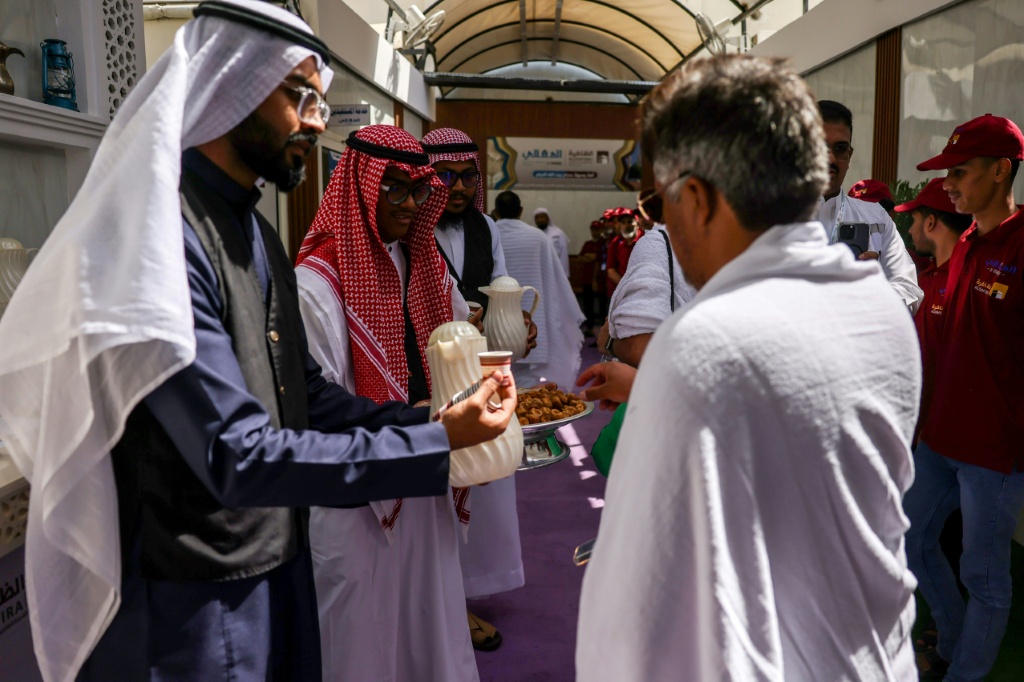 حجاج مسلمون يستقبلون بالشاي والتمور في منى قرب مكة المكرمة في المملكة العربية السعودية في الثالث من حزيران/يونيو 2025 (أ ف ب)