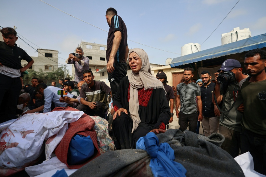 فلسطينيون يحيطون بجثث أقارب لهم في مستشفى شهداء الأقصى في دير البلح وسط قطاع غزة في 18 أيار/مايو 2025 (أ ف ب)