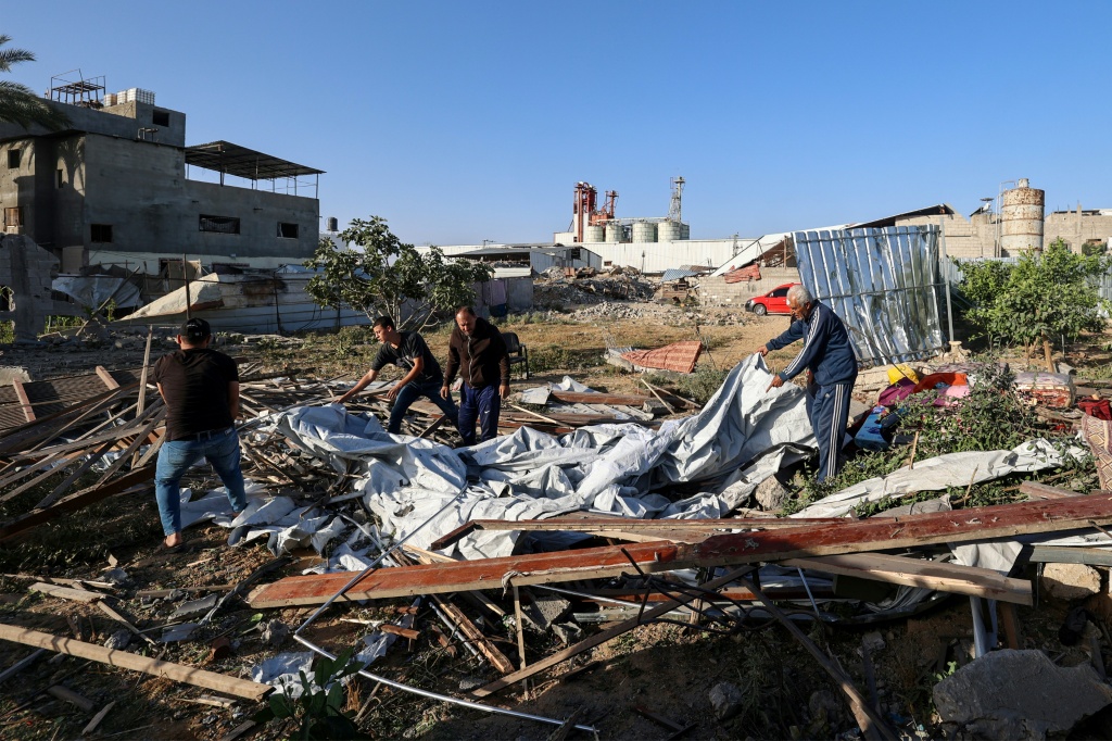 فلسطينيون يبحثون بين الركام قرب منزل استهدفته غارة اسرائيلية في مخيم النصيرات وسط غزة في 24 ايار/مايو 2025. (ا ف ب)