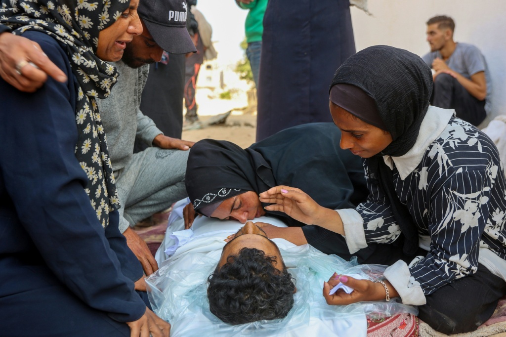نساء ينتحبن على جثمان رجل قُتل في القصف الإسرائيلي خلال الليل في 12 حزيران/يونيو 2025، في مستشفى الشفاء في مدينة غزة (أ ف ب)