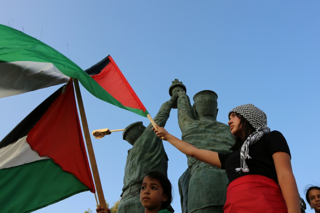 يرفع الشباب التونسي الأعلام الفلسطينية أثناء استقبالهم لقافلة الصمود في مدينة بن قردان في جنوب البلاد. (أ ف ب)