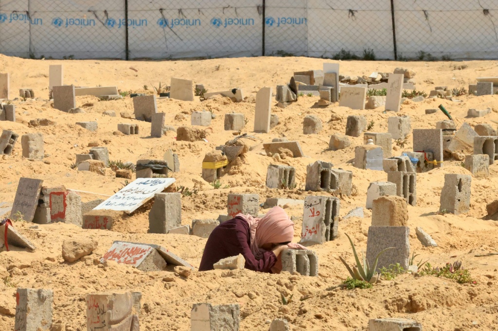 فلسطينية تبكي بجوار قبر قريب لها في خان يونس جنوب قطاع غزة في 16 حزيران/يونيو 2025 (أ ف ب)