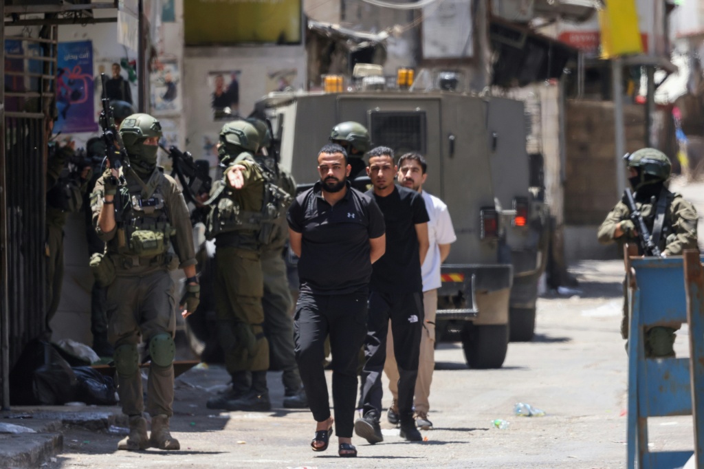 قوات إسرائيلية تعتقل فلسطينيين خلال مداهمة مخيم بلاطة للاجئين شرقي مدينة نابلس في الضفة الغربية المحتلة، في 18 حزيران/يونيو 2025 (أ ف ب)