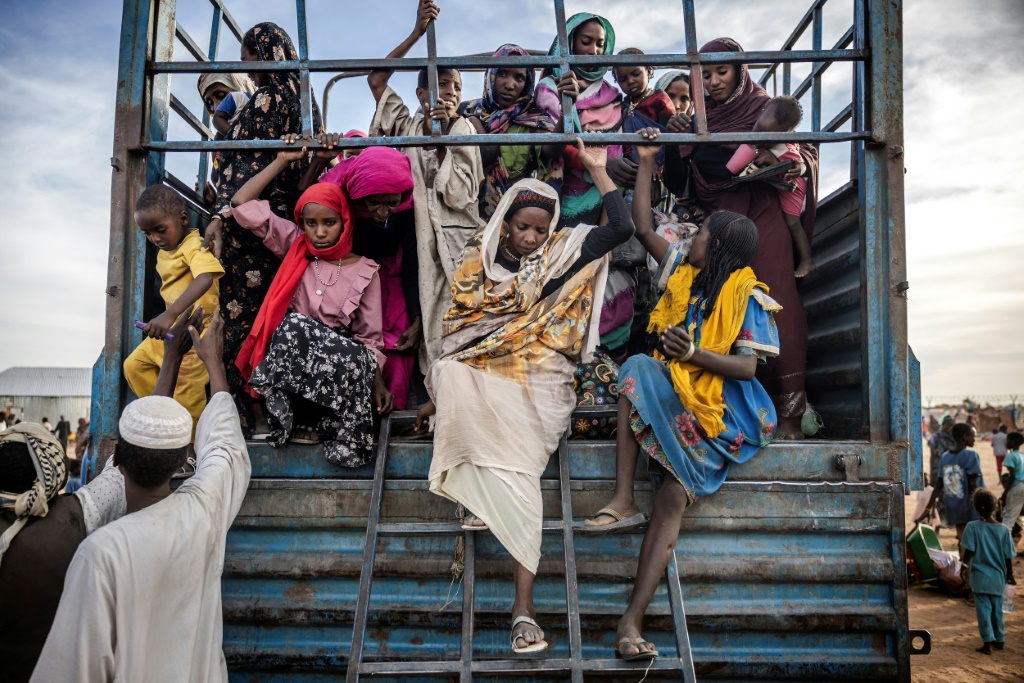 لاجئون سودانيون فروا من الحرب في بلادهم ينزلون من شاحنة محملة بعائلات تصل إلى مركز عبور للاجئين في الرنك بجنوب السودان في 13 شباط/فبراير 2024 (أ ف ب)