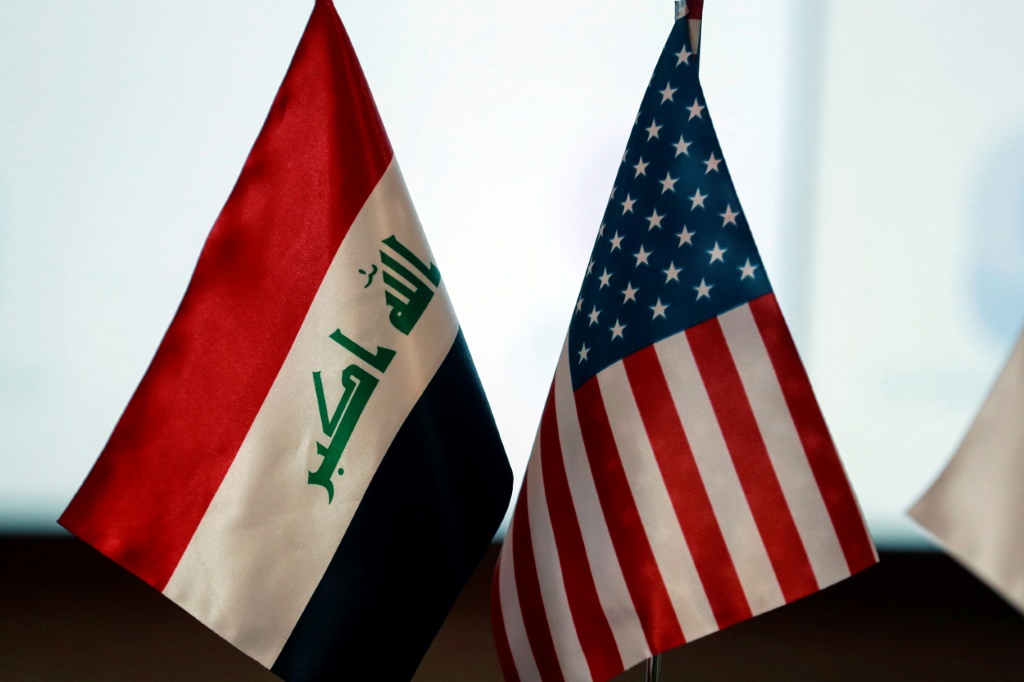 علم العراق (يسار) وعلم الولايات المتحدة خلال محاضرة في الجامعة الأميركية في بغداد في التاسع من نيسان/أبريل 2025 (أ ف ب)