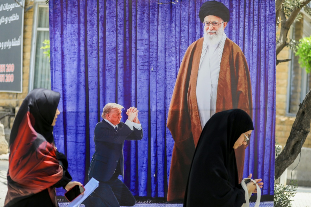 صورة تظهر الرئيس الأميركي دونالد ترامب وهو راكع أمام المرشد الأعلى الإيراني آية الله علي خامنئي في ضاحية بيروت الجنوبية بتاريخ 25 حزيران/يونيو 2025 (أ ف ب)