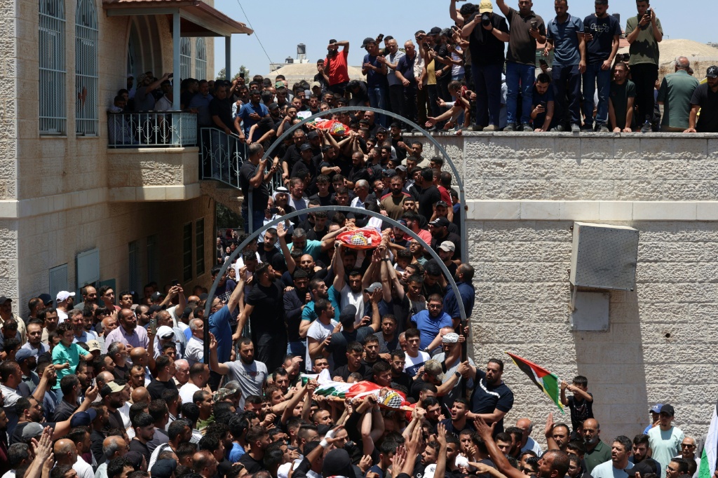 مشيعون فلسطينيون في 26 حزيران/يونيو 2025 في جنازة ثلاثة أشخاص قُتلوا خلال هجوم للمستوطنين في اليوم السابق على قرية كفر مالك في الضفة الغربية المحتلة (أ ف ب)