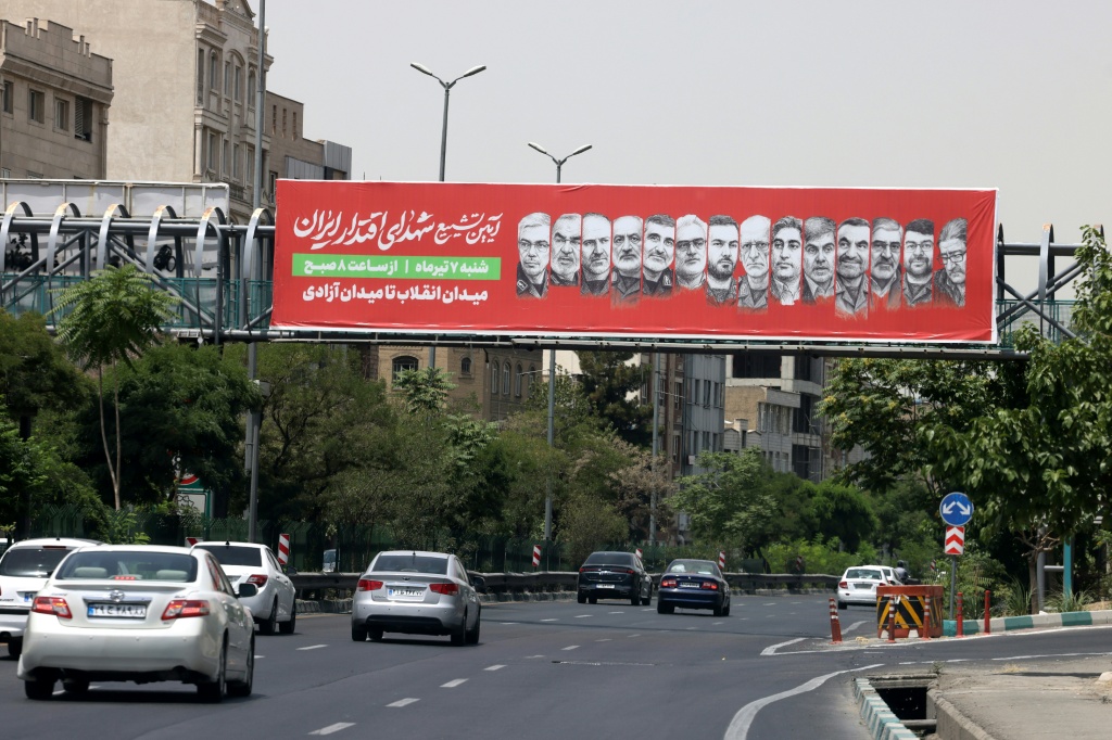 ملصق فوق طريق سريع في طهران يحمل صور عدد من القادة والعلماء الذين قتلوا في الحرب مع إسرائيل، في صورة مؤرخة 26 حزيران/يونيو 2026 (أ ف ب)