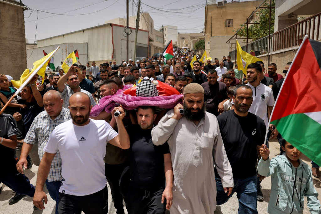 مشيعون يحملون جثمان الفتى أمجد حوشية الذي قتل خلال مداهمة الجيش الإسرائيلي مدينة رام الله فجر 1 تموز/يوليو 2025 خلال جنازته في قرية يطا جنوب مدينة الخليل بالضفة الغربية المحتلة (أ ف ب)
