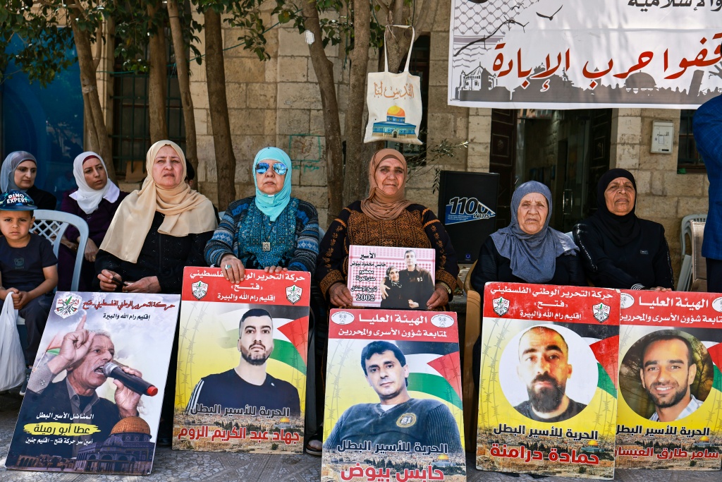 فلسطينيات يحملن صور معتقلين لدى إسرائيل خلال وقفة تضاما معهم في رام الله بالضفة الغربية المحتلة في 6 أيار/مايو 2025 (أ ف ب)