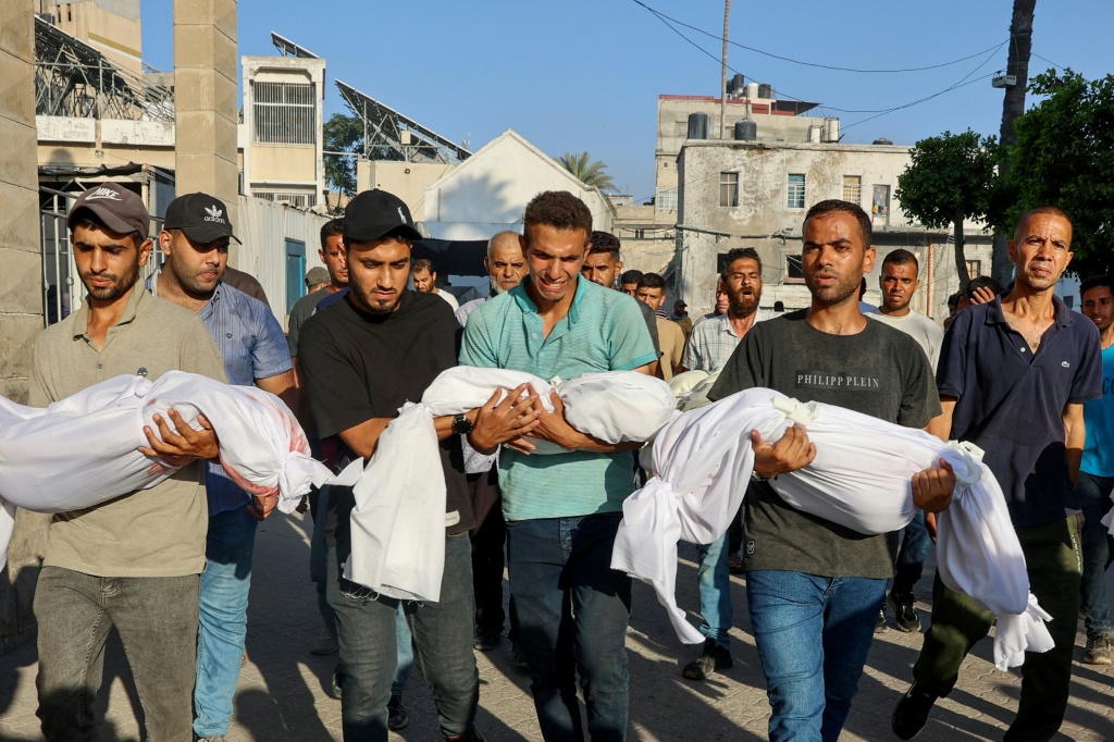 فلسطينيون يحملون جثامين اطفال قضوا في وقت سابق في ضربة إسرائيلية على مدينة غزة خلال تشييعهم من المستشفى المعداني إلى مقبرة في الثاني من تموز/يوليو 2025 (أ ف ب)