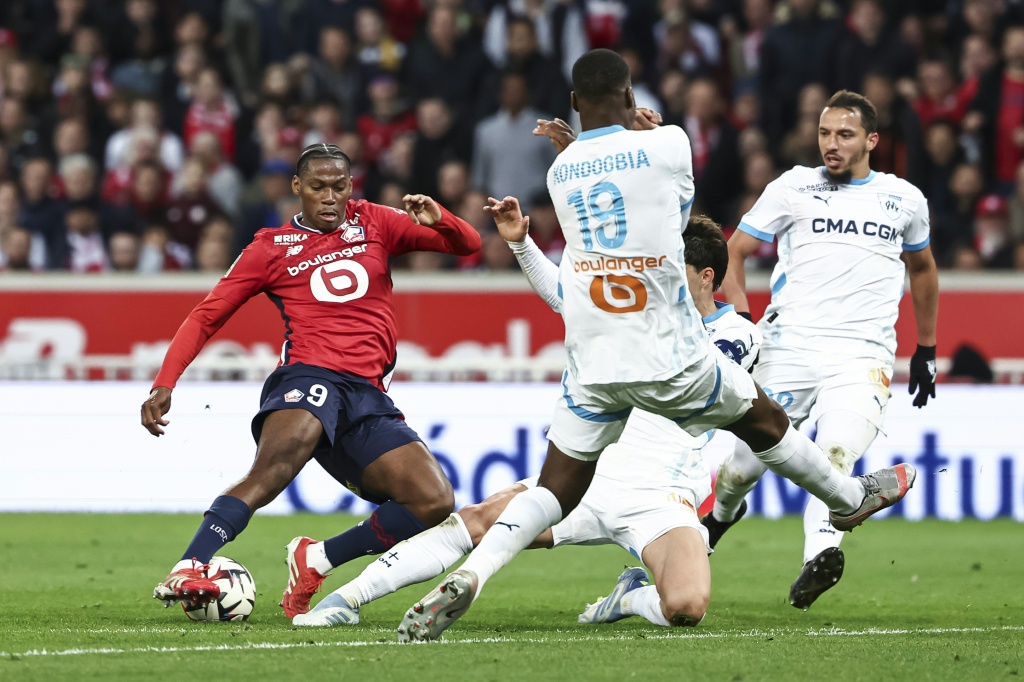 المهجم الدولي الكندي جوناثان ديفيد (يسار) خلال مباراة فريقه ليل مع مرسيليا في الدوري الفرنسي على ملعب فيلنوف-داسك في ليل في الرابع من أيار/مايو 2025 (أ ف ب)