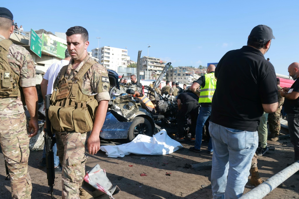 عناصر من الجيش اللبناني ومسعفون يحيطيون بسيارة استهدفتها غارة إسرائيلية على الطريق السريع في بلدة خلدة جنوب بيروت في الثالث من تموز/يوليو 2025 (أ ف ب)